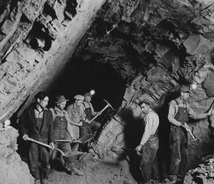 A black and white image of men mining in a tunnel in Golden, Colorado.
